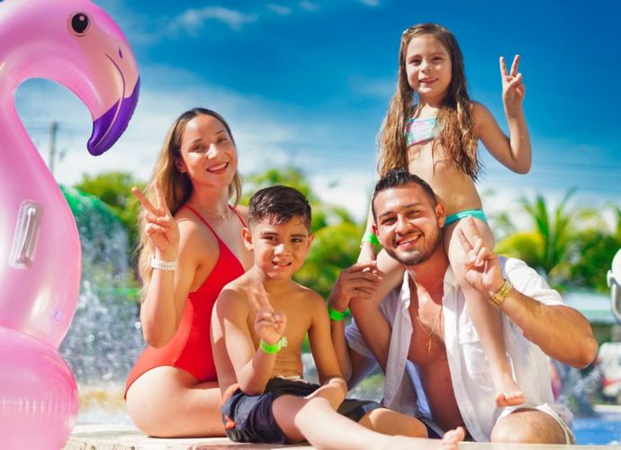 Family enjoying a sunny day by the pool with a pink flamingo float, creating joyful memories.